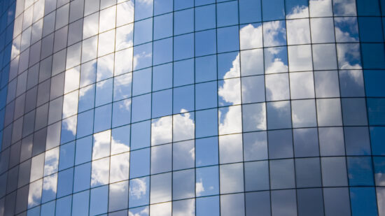 Futuristic abstract business background with reflected blue skies and clouds